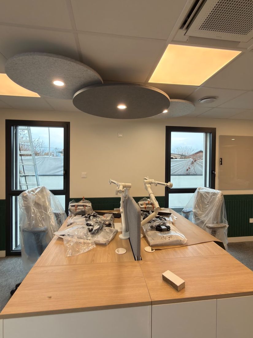 Bureaux éclairés par des spots intégrés à des panneaux acoustiques et des dalles LED